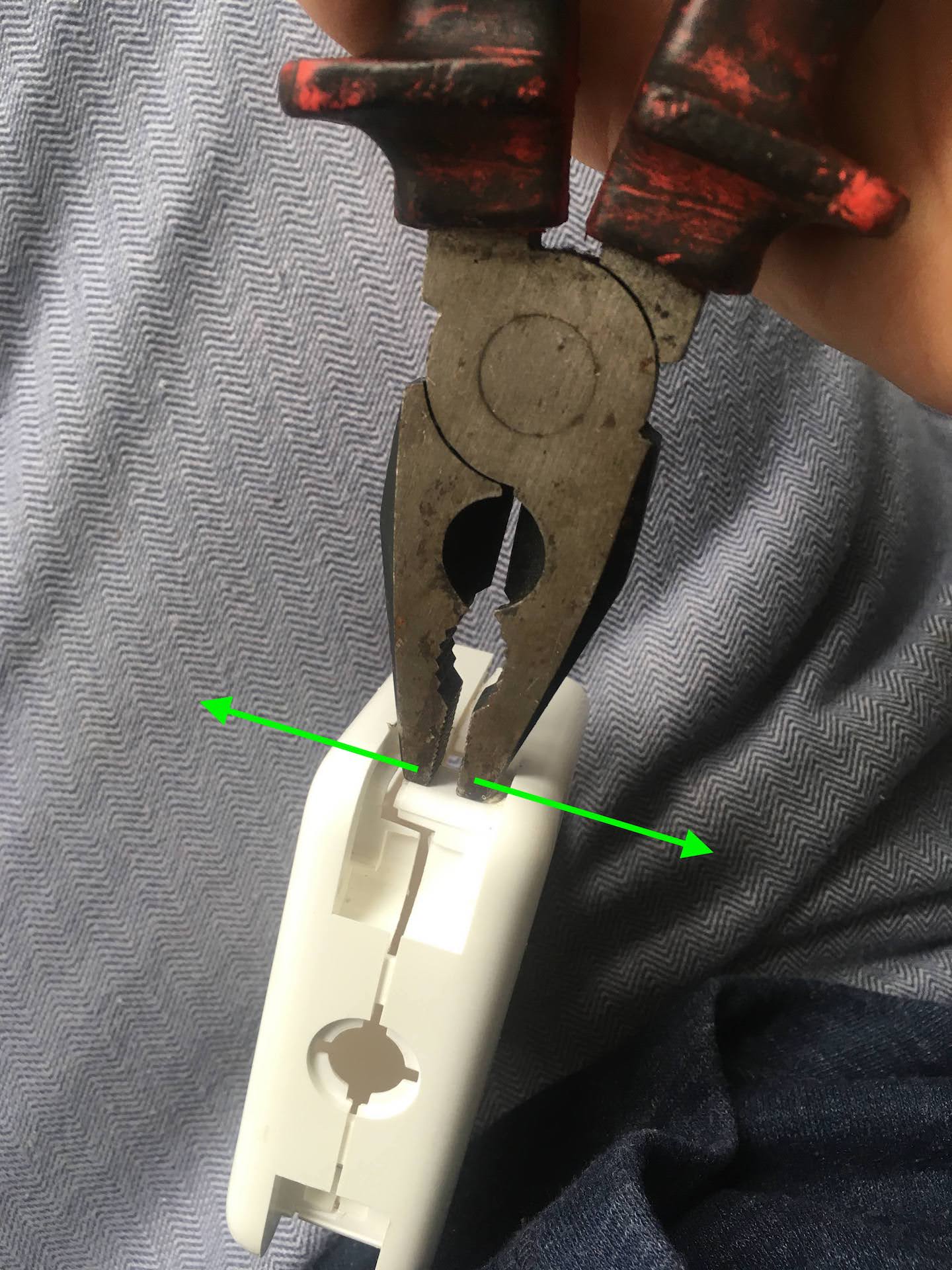 Using flat head pliers to open a MacBook Charger